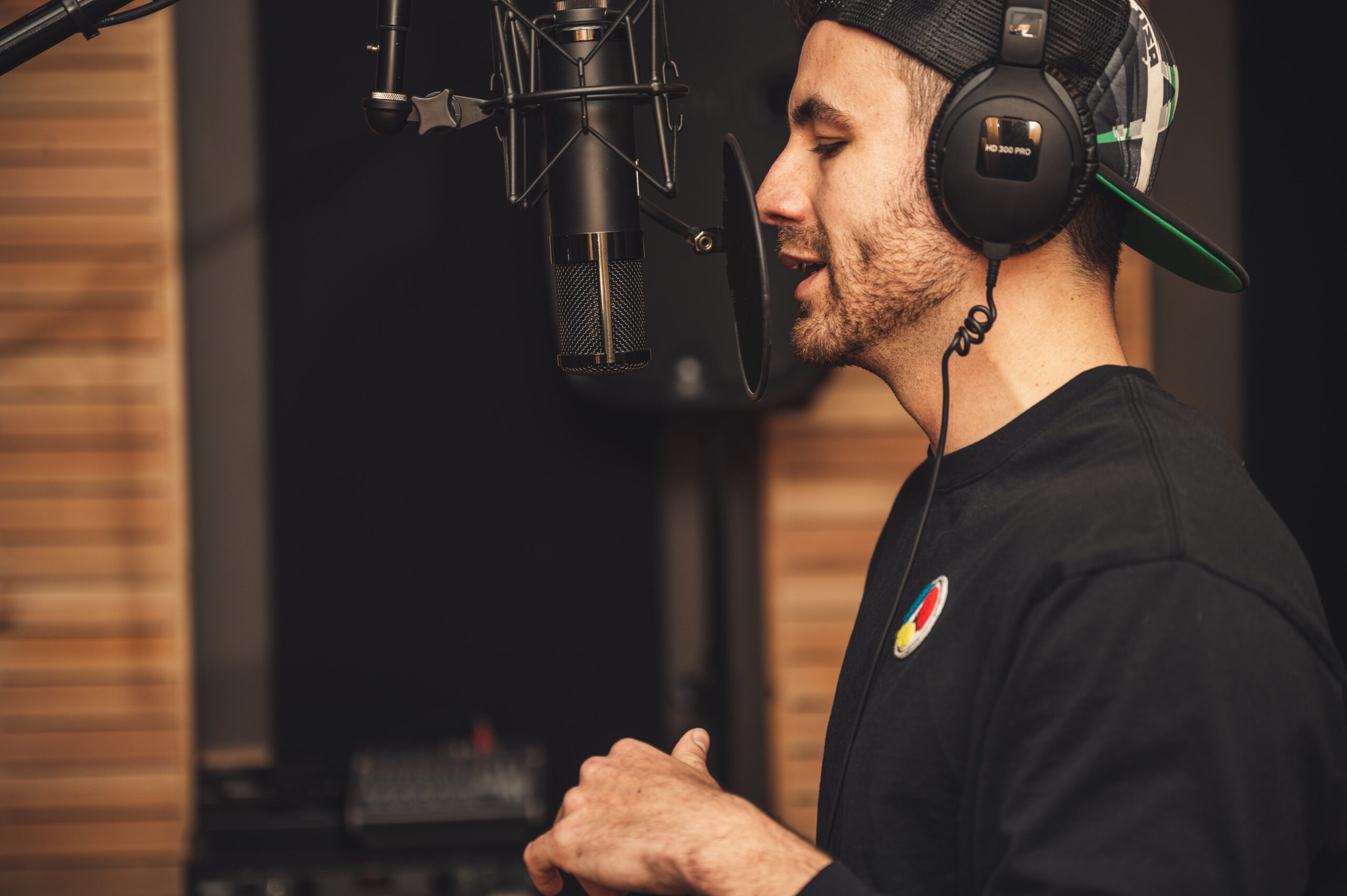 Άντρας φοράει ακουστικά και ηχογραφεί podcast σε studio